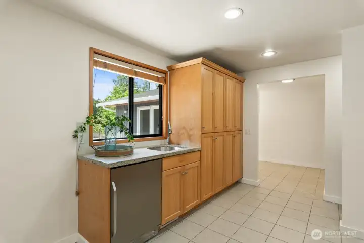 Wet bar with built-in beverage fridge and able pantry cabinetry