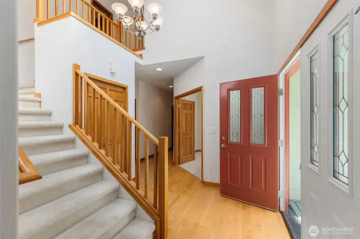 The entry opens to a wide staircase with warm wood railings and a clear sightline through the main floor — the layout feels generous from the start. The entry opens to a wide staircase with warm wood railings and a clear sightline through the main floor — the layout feels generous from the start.