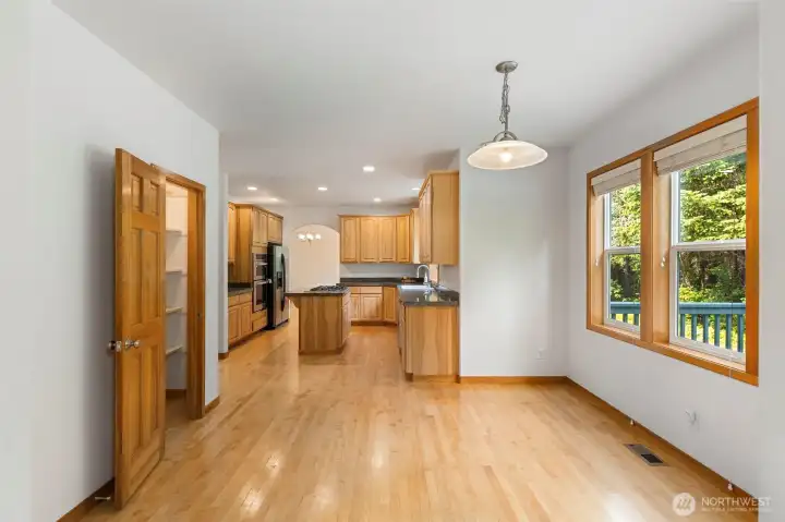 A well-proportioned kitchen with ample cabinetry, granite counters, stainless appliances, and a pantry just off to the left — with a glimpse of the deck through the window. A well-proportioned kitchen with ample cabinetry, granite counters, stainless appliances, and a pantry just off to the left — with a glimpse of the deck through the window.