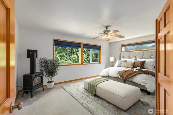 The primary suite has a propane wood stove, treetop views from multiple windows, and enough room to truly unwind. Virtually staged. The primary suite has a propane wood stove, treetop views from multiple windows, and enough room to truly unwind. Virtually staged.