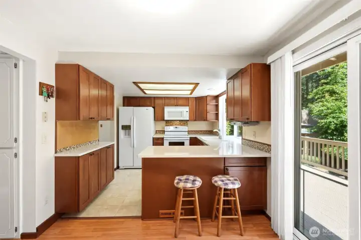 View of remodeled kitchen with breakfast bar from the informal eating area.