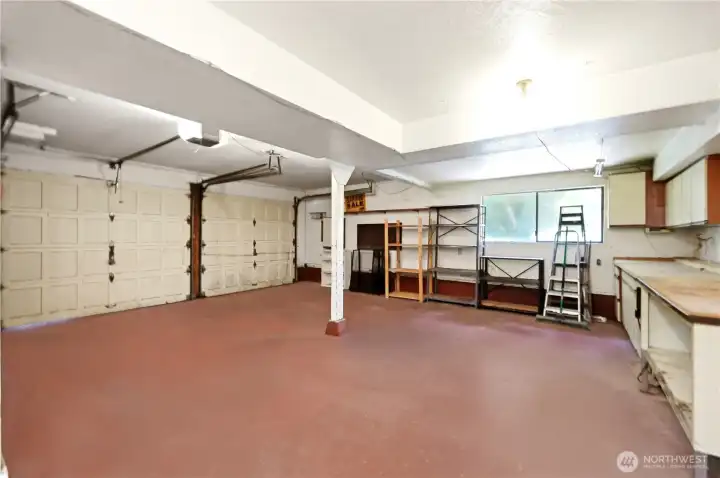 Big 2-car garage with workbench and cabinet storage.