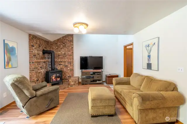 Family room is off the kitchen. The Brick hearth and brick wall is a great accent for the free standing gas fireplace.  There is a sliding door off this room that leads to the fully fenced back yard with hot tub, free standing wood deck, and area for RV parking.