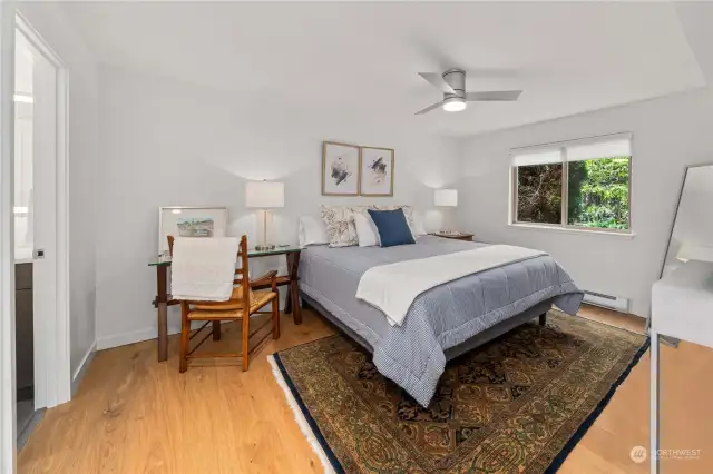 Generous primary bedroom continues with a light and bright pallet with a ceiling fan to keep the air circulated.