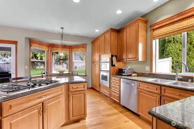 Chef's kitchen with storage/cabinets galore!  Stainless appliances, wall oven, gas cook top, hardwood floors, eating area and granite counter tops.