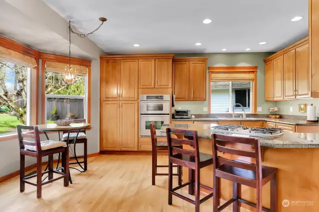 Chef's kitchen with storage/cabinets galore!  Stainless appliances, wall oven, gas cook top, hardwood floors, eating area and granite counter tops.