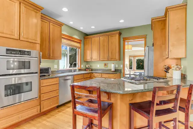 Chef's kitchen with storage/cabinets galore!  Stainless appliances, wall oven, gas cook top, hardwood floors, eating area and granite counter tops.