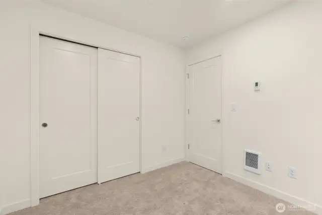 This room features thoughtful storage and enough wall space for a gallery or a workspace setup.