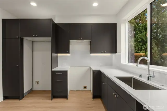 Your future kitchen is equal parts sleek and functional. Matte black cabinets, quartz countertops, and a giant window to gaze out.