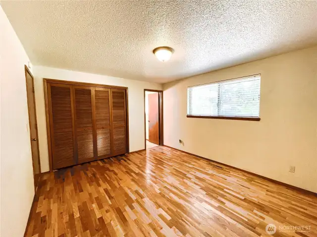 Primary bedroom with original hardwood floors and en suite bathroom.