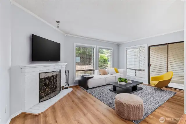 Living area with wood fireplace and door to patio. Virtually staged.