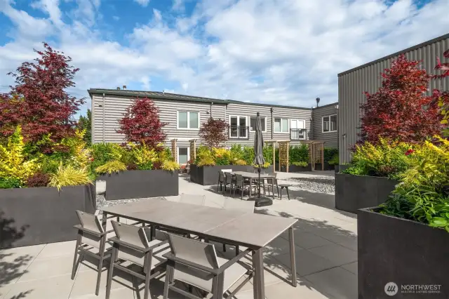 A few large tables and chairs invite community, with a grill and gorgeous greenery who wouldn't want to have dinner on the roof top?