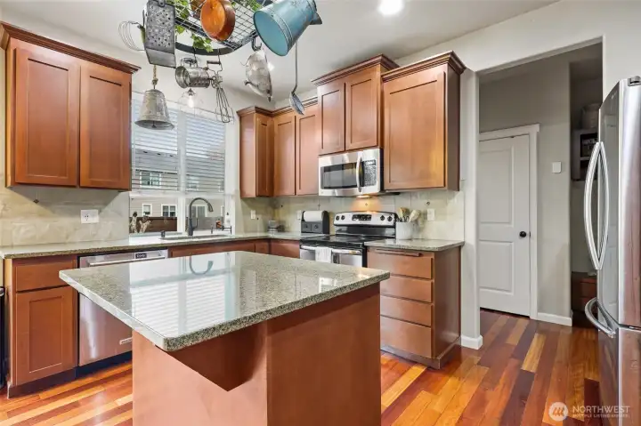 Tile backsplash and crown molding reveal the quality found in this home. Far door seen here is the extra pantry, with 1/2 bath and garage access in that same hallway.