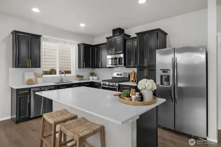 Beautiful quartz countertops, birch cabinets with large hardware, and island eating.