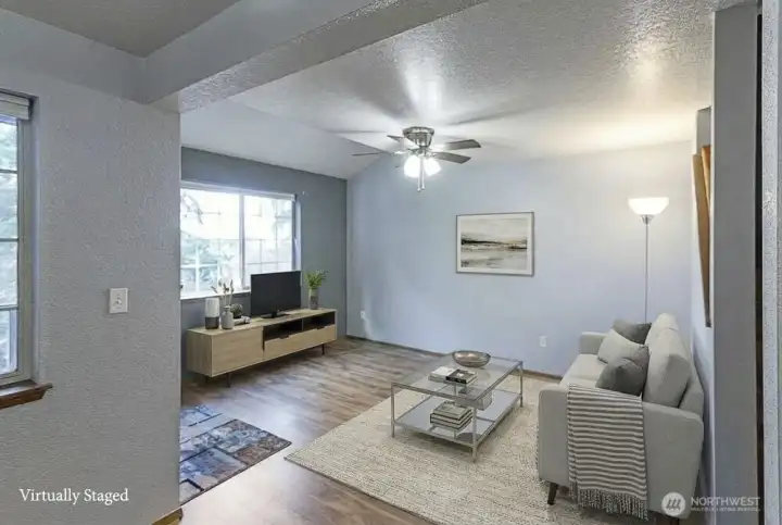 Open main floor plan creating a bright and welcoming space. Features durable laminate flooring throughout, complemented by tasteful and modern updates, enhancing the overall appeal and comfort of the home.