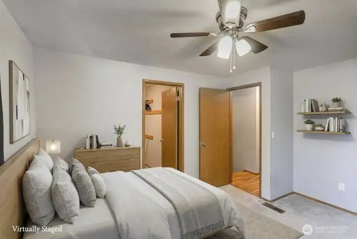 This photo provides a different perspective of the primary bedroom, specifically highlighting the ceiling fans as a key feature of the space and showcasing the room's overall ambiance.