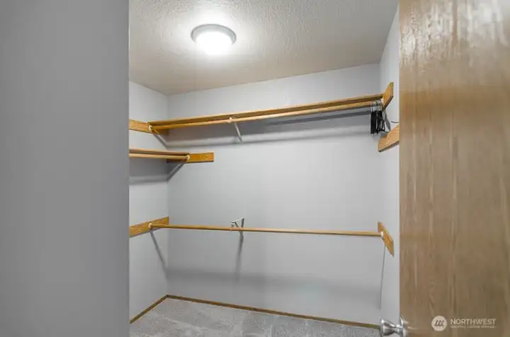 Primary walk-in closet has loads of storage. The closet is spacious, offering ample room for clothing, shoes, and accessories, ensuring a well-organized and functional space.