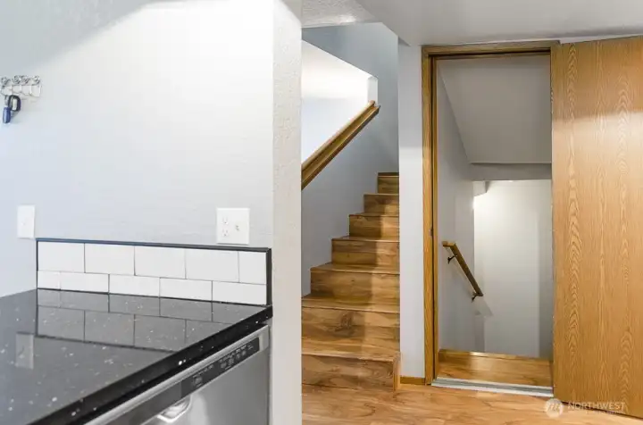 This photo showcases the kitchen's layout, providing a clear view of the staircase leading to the second floor and highlighting the convenient access to the attached two-car tandem garage.