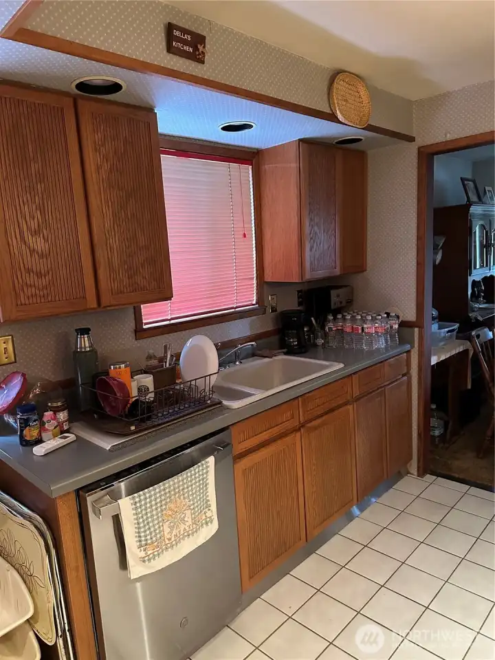 Dishwasher, sink, cabinets and window for natural light