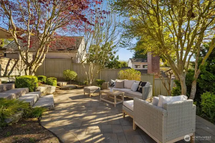 Large, professionally landscaped backyard with multiple spaces for entertaining and enjoying.