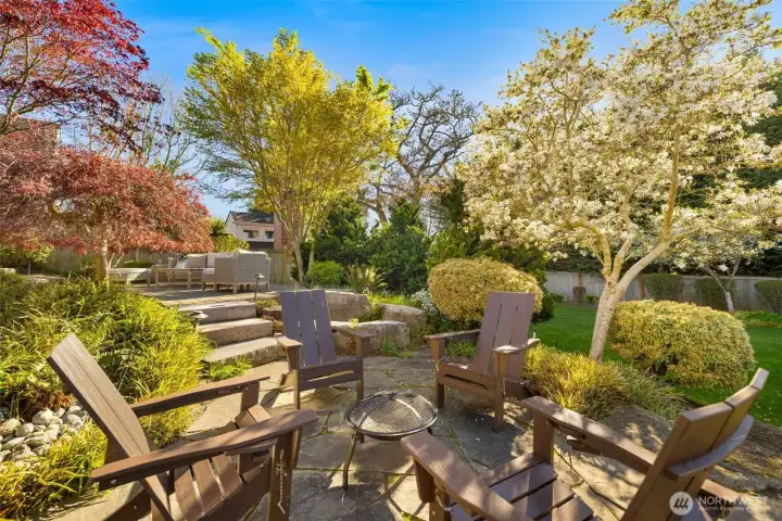 Large, professionally landscaped backyard with multiple spaces for entertaining and enjoying.