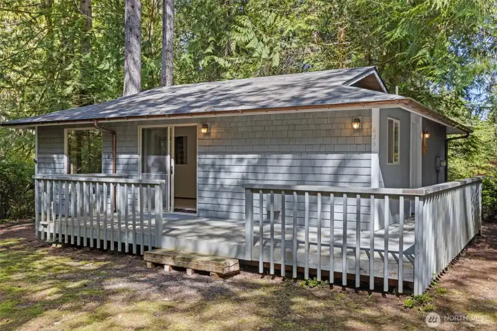 Cabin in the woods with partial wrap around deck and large slider to open living room/dining area/kitchen