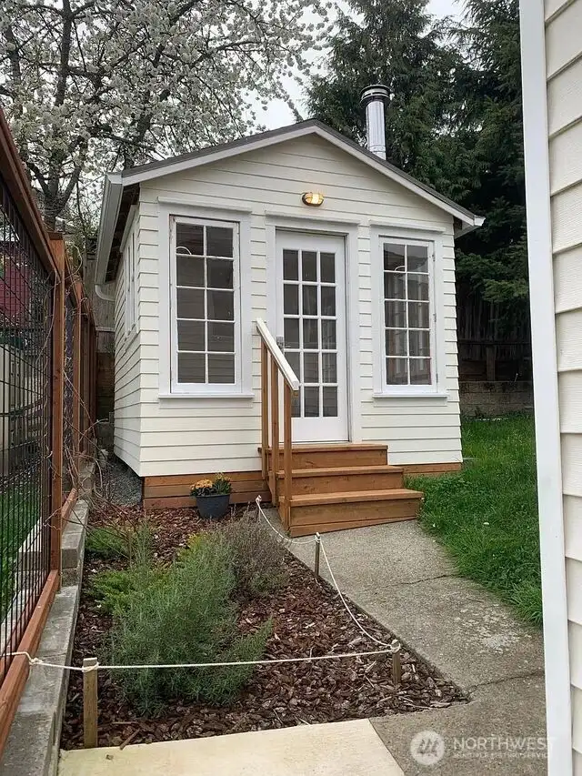 Charming & useful backyard cottage. Raised up, added drainage, windows, electrical, insulation, drywall, flooring & wood stove.