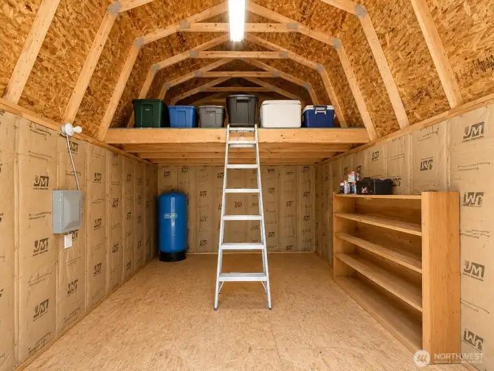 Exceptional storage and organization space featuring a fully insulated interior, electrical service, built-in shelving, and a spacious loft for seasonal items, equipment, and supplies. The vaulted ceiling design maximizes storage capacity while maintaining easy access and functionality. Ideal for tools, outdoor gear, hobby materials, workshop overflow, or secure long-term storage. A valuable addition to the property that offers flexibility, convenience, and abundant storage options for a variety of needs.