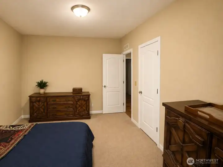 This well-appointed secondary bedroom offers a peaceful retreat with neutral colors, soft carpeting, and abundant natural light. A spacious closet provides convenient storage, while the versatile layout easily accommodates guests, family members, or a home office setup. Clean lines and warm finishes create a welcoming space ready for your personal touch.