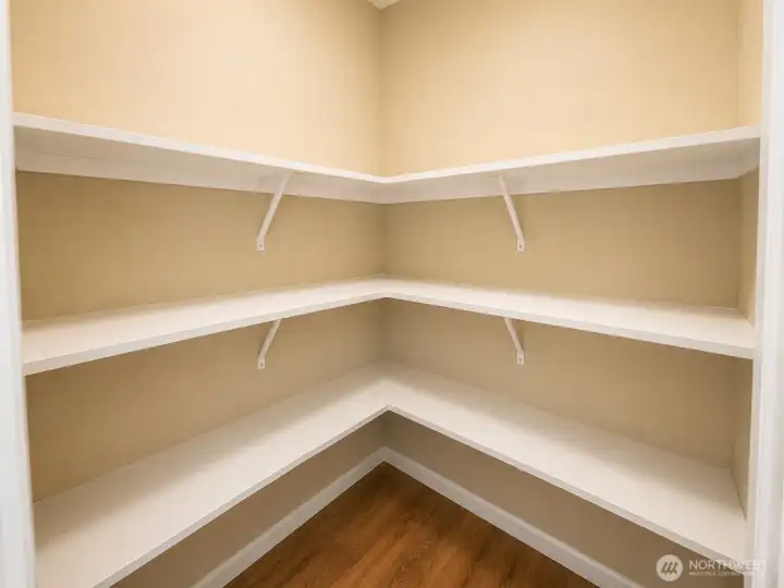 Large walk-in pantry with extensive wraparound shelving provides exceptional storage for groceries, small appliances, bulk items, and household essentials. Thoughtfully designed with multiple levels of shelving and easy access from the kitchen, this organized storage space helps keep the main living areas clutter-free while maximizing functionality for everyday living.
