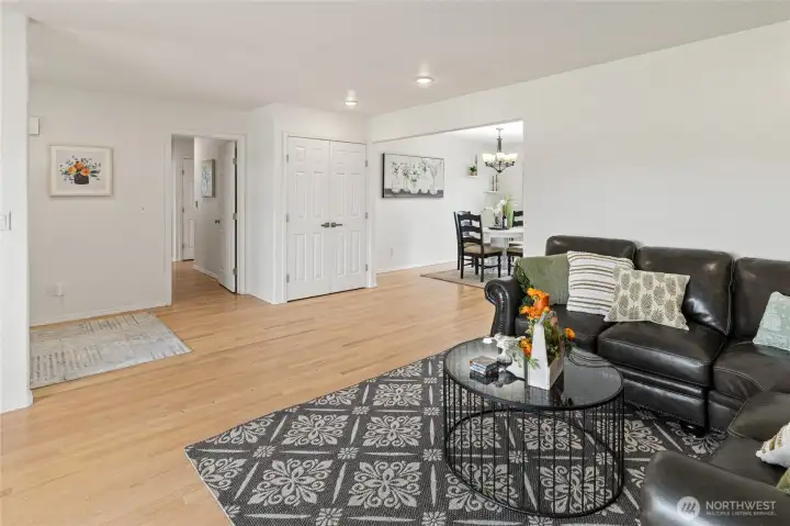 A view from the living room towards the entrance of the home, straight a head is the hall towards bedrooms, bathroom and utility room, and to the right is the dining room and kitchen entrance.