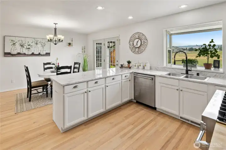 A view of the kitchen looking out to the beautiful backyard and off to the left the dining room.