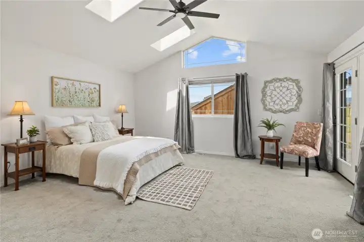 A view of the massive primary bedroom with nice French doors out to the rear patio area.