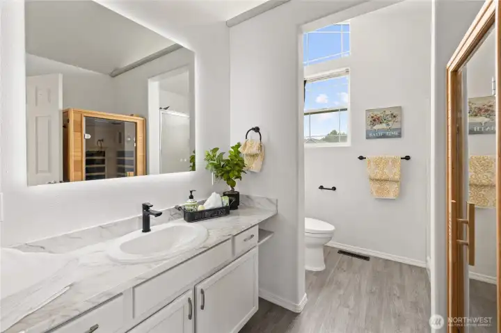 Primary bedroom bathroom with a large lighted mirror.