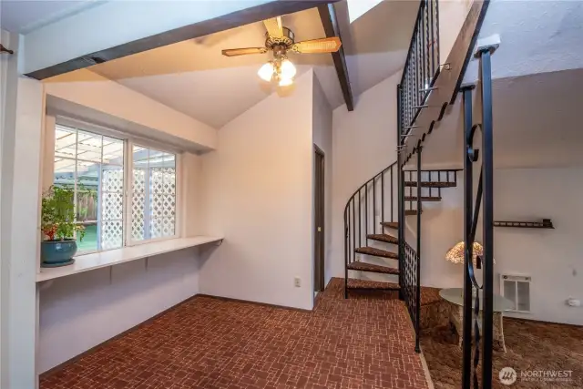 Dining room with vaulted ceiling. View to the half bath and spiral staircase to loft.