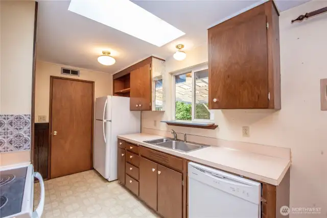 Galley kitchen with built in pantry & skylight.