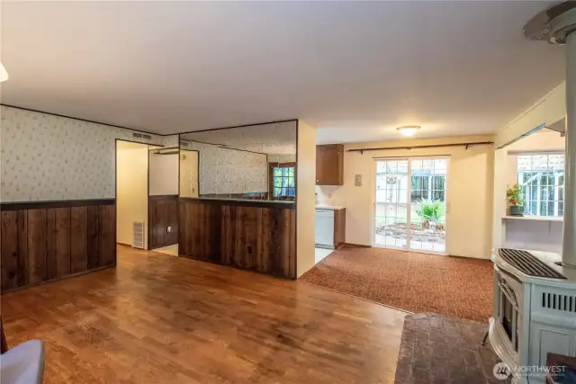 Living room with hardwood floors & groovy mirrored wall detail.