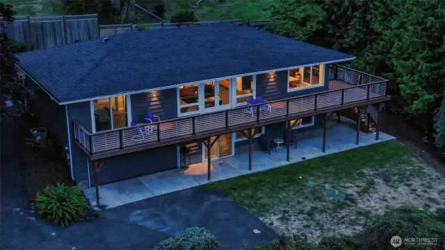 Two distinct levels offer dual living flexibility. Top level entry is from back enclosed garden. Enter to foyer and living room, seen here in the middle with french doors out to the deck. Main BR on left, 2nd BR/office across hall. Kitchen and dining to right.  Lower level has multiple entry point including slider seen in middle.