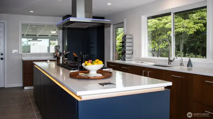 Bauformat kitchen cabinets have fully adjustable shelves and deep drawer storage with slide-back utensil trays.  Cabinets are finished in matte lacquer and wood grain. Handleless island illumined by LED mood lighting.