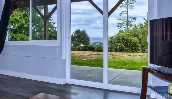 Large multi-purpose room on lower level with small built-in desk and sliders to the patio.