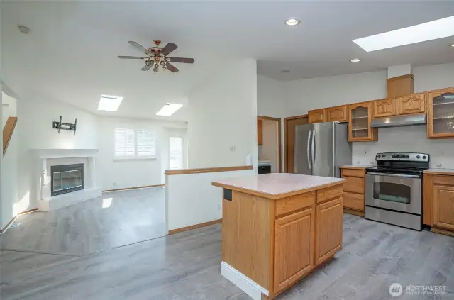 Skylights flood the open layout—dining area connects beautifully to the kitchen and living room.