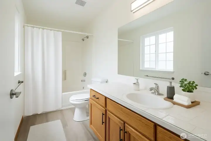 Guest full bath on the main floor feels spacious and bright - Virtual Staged