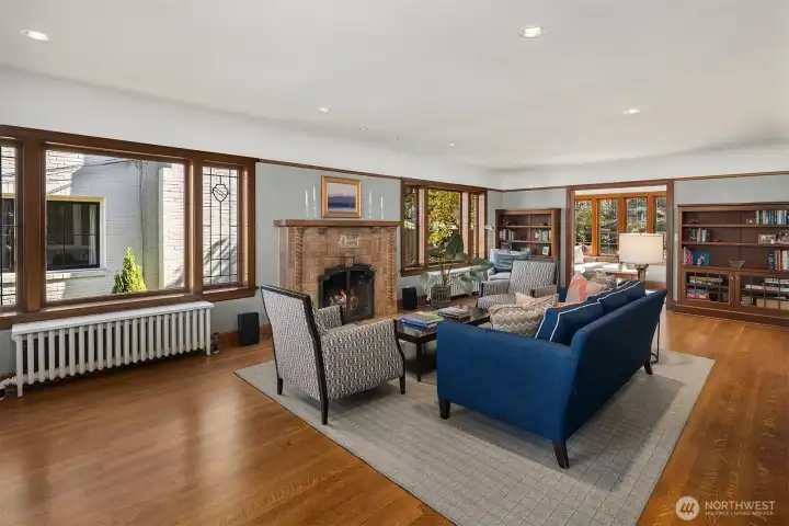As you step inside, you’re welcomed by a spacious living room anchored by an original Batchelder tile fireplace and complemented by timeless, refinished oak hardwood floors.