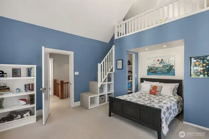 This bedroom boasts vaulted ceilings and a custom-built loft, combining architectural drama with functional charm.