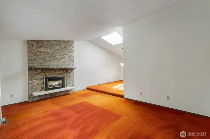 Unstaged living room, natural gas fireplace and partial dining room view.