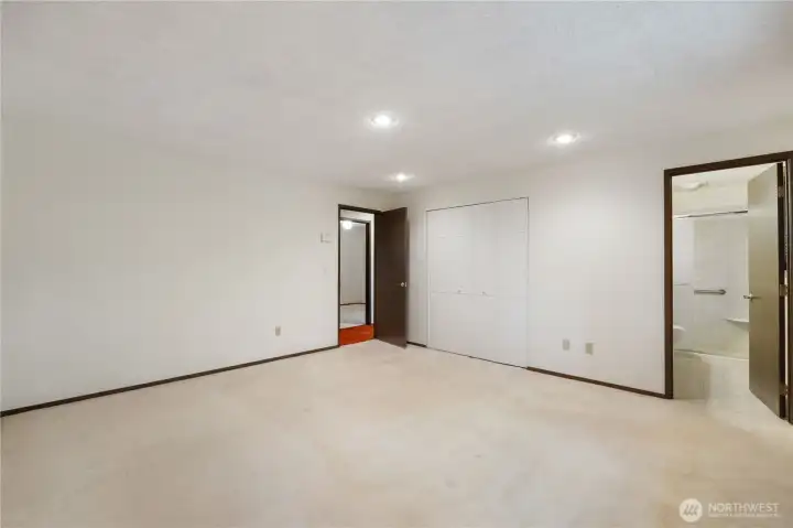 Upstaged Primary bedroom with partial view of 3/4 bathroom.