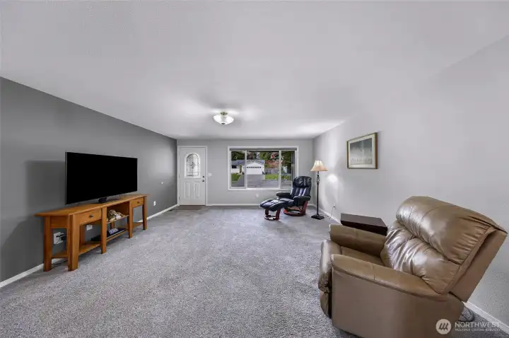 Main living view from kitchen to large picture window, new carpet and fresh paint!