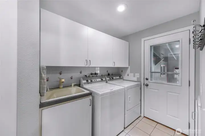 Full utility room off kitchen with utility sink, additional storage and pass through from garage to backyard/patio area
