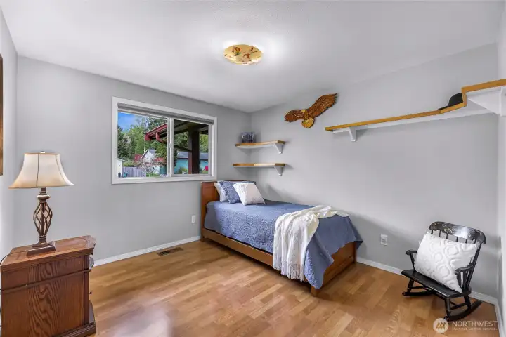 Bedroom 1 with built in shelving and large closet, with custom blackout pull down blinds