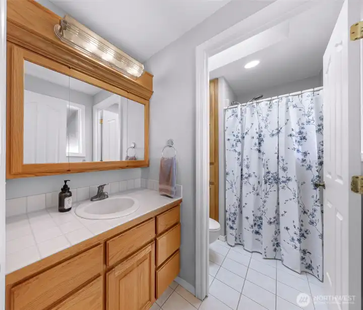 3/4 Bath off primary with privacy door between vanity and shower. Tons of storage with pull out cabinets in bath area.